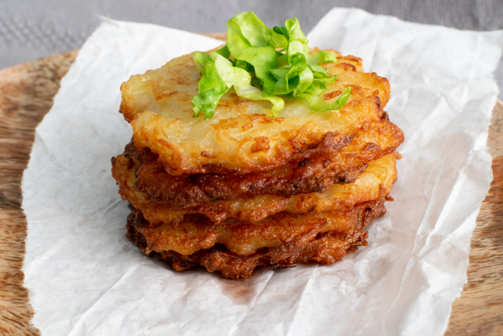 5 fried and crunchy sweet potato fritters resting on a paper towel